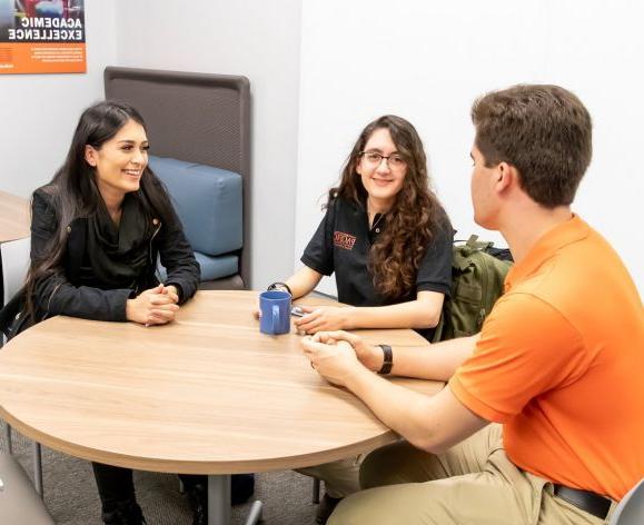 education students sitting around a table talking